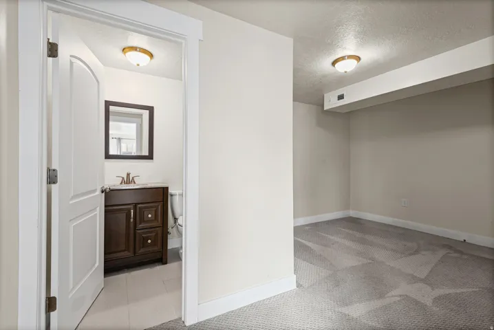 Well-appointed bathroom featuring a dark wood vanity, framed mirror, and light tile flooring
