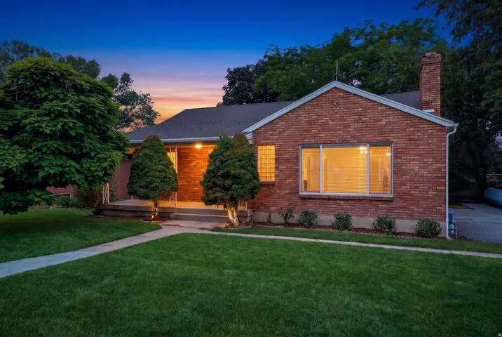 Brick exterior with a prominent chimney and a paved driveway