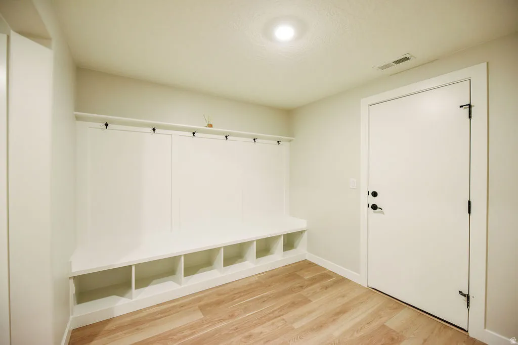 Built-in mudroom bench with cubby storage and black coat hooks