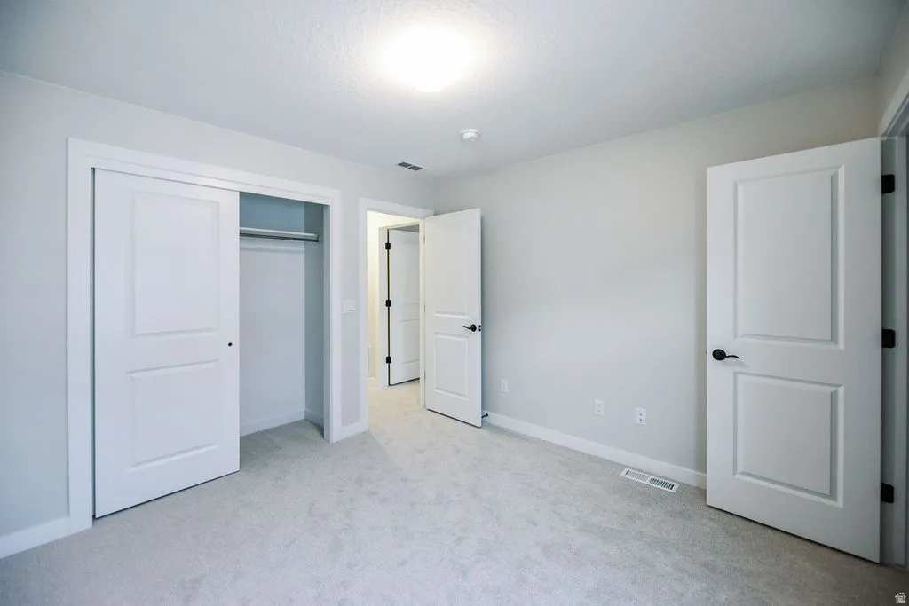 Carpeted room with a sliding closet featuring a hanging rod