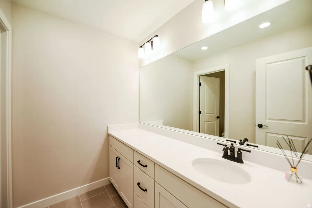 Bathroom vanity featuring a solid surface countertop with an integrated sink and matte black faucet