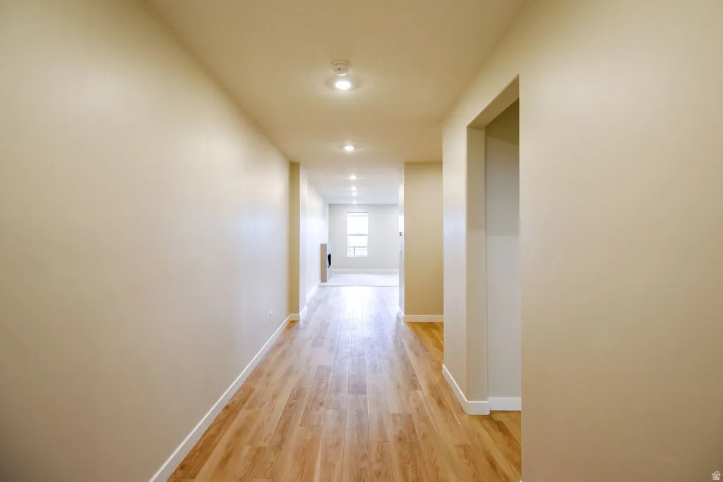 Hallway featuring wood-finish flooring, recessed lighting, and neutral wall tones