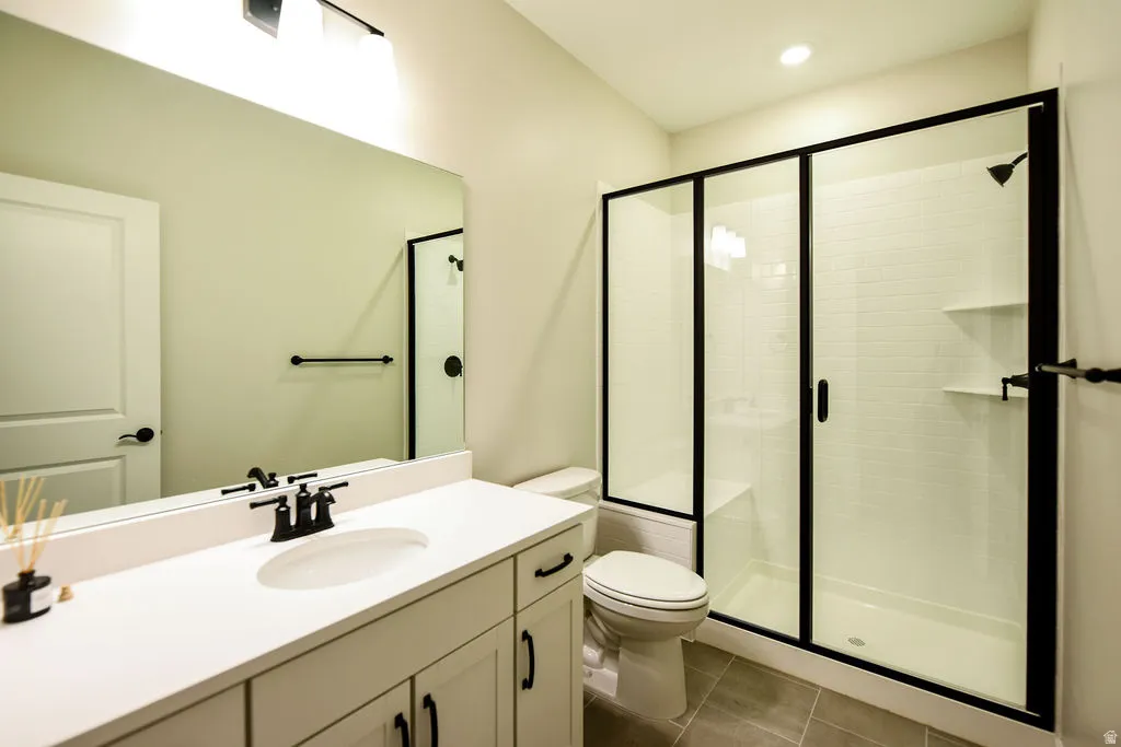 Bathroom featuring a white vanity with built-in sink, black-framed mirror, and matte black fixtures