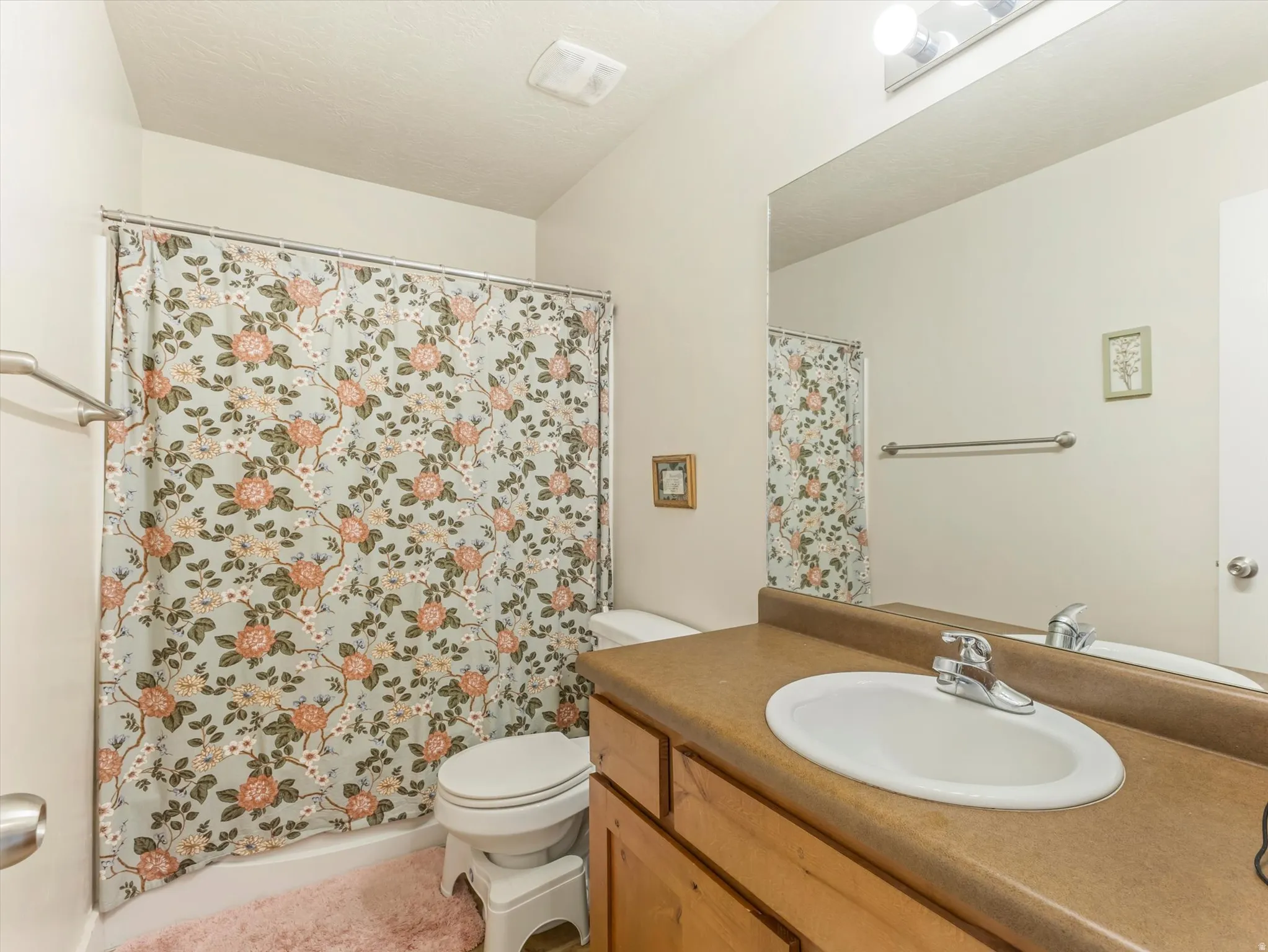 Bathroom featuring a vanity with a drop-in sink, chrome faucet, and a large mirror
