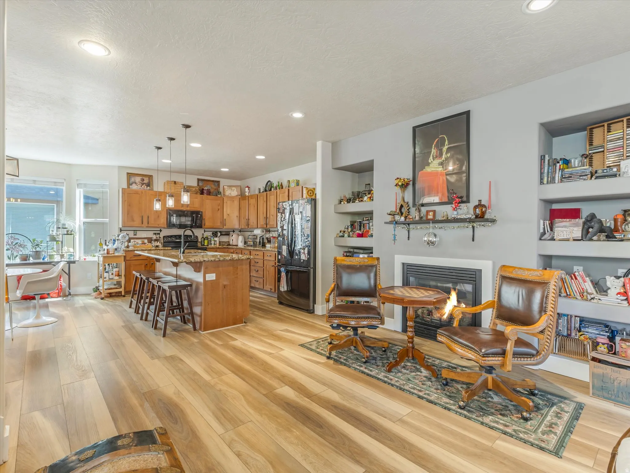 Open-concept living space featuring wood-finish flooring, recessed lighting, and a modern kitchen