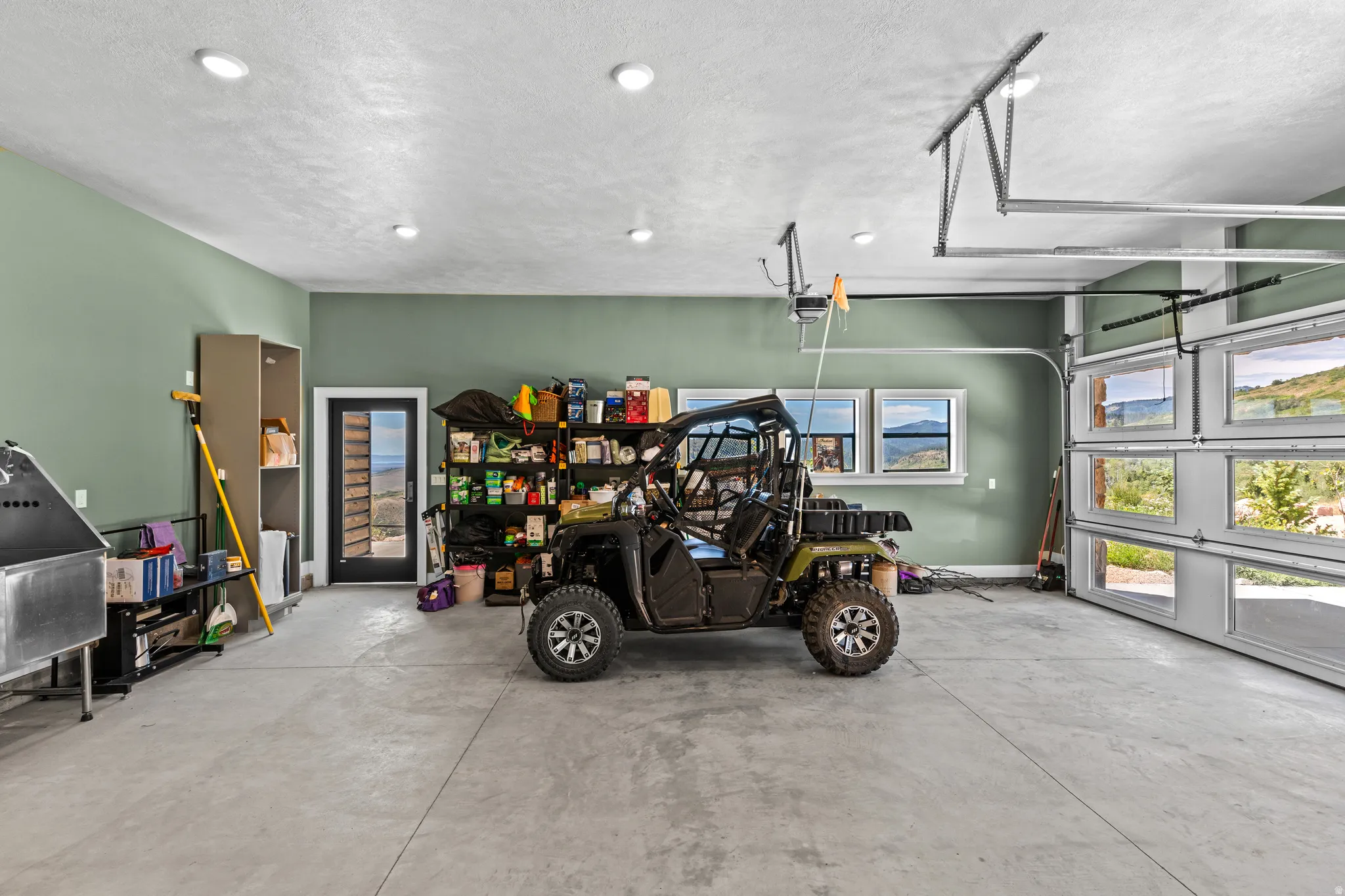 Spacious garage featuring a concrete floor, recessed lighting, and ample natural light from three transom windows and a full-view garage door