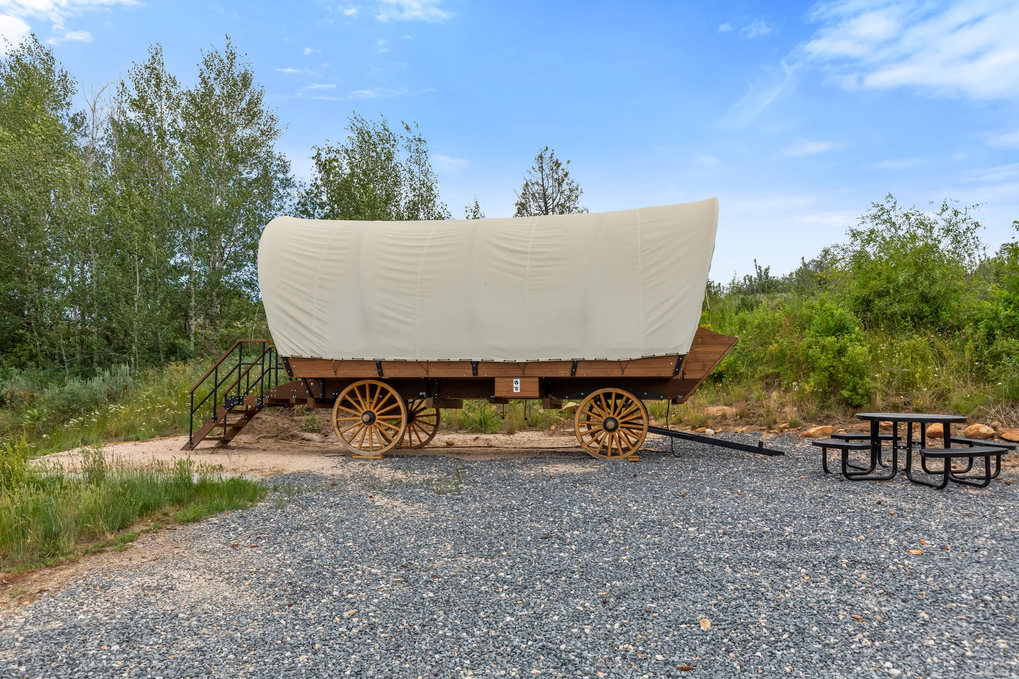 Covered wagon structure featuring a canvas top and wooden wheels
