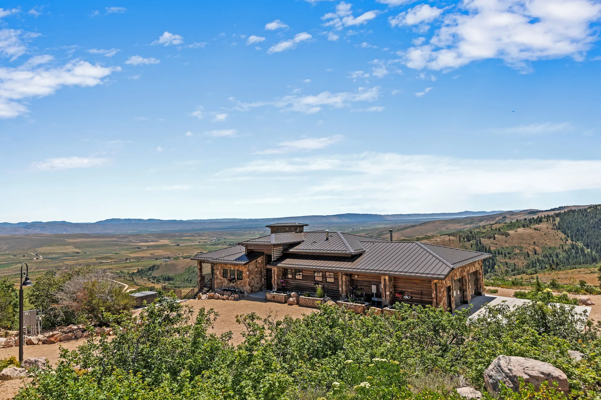 Expansive log and stone residence featuring a multi-gabled metal roof