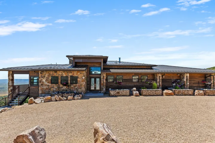 Ranch-style residence featuring natural stone and wood siding