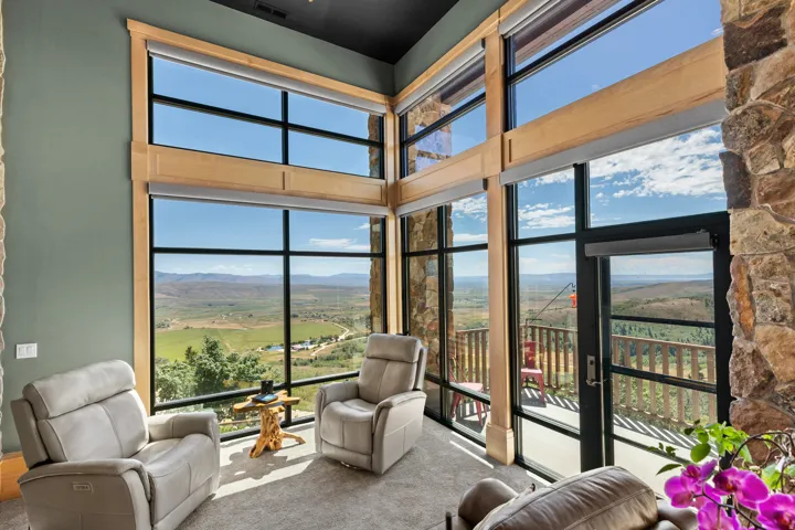 Two-story windows featuring wood framing and roller shades