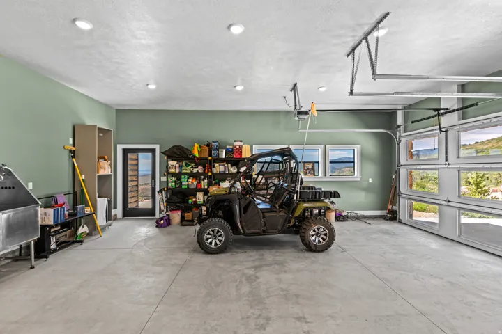 Spacious garage featuring a concrete floor, recessed lighting, and ample natural light from three transom windows and a full-view garage door