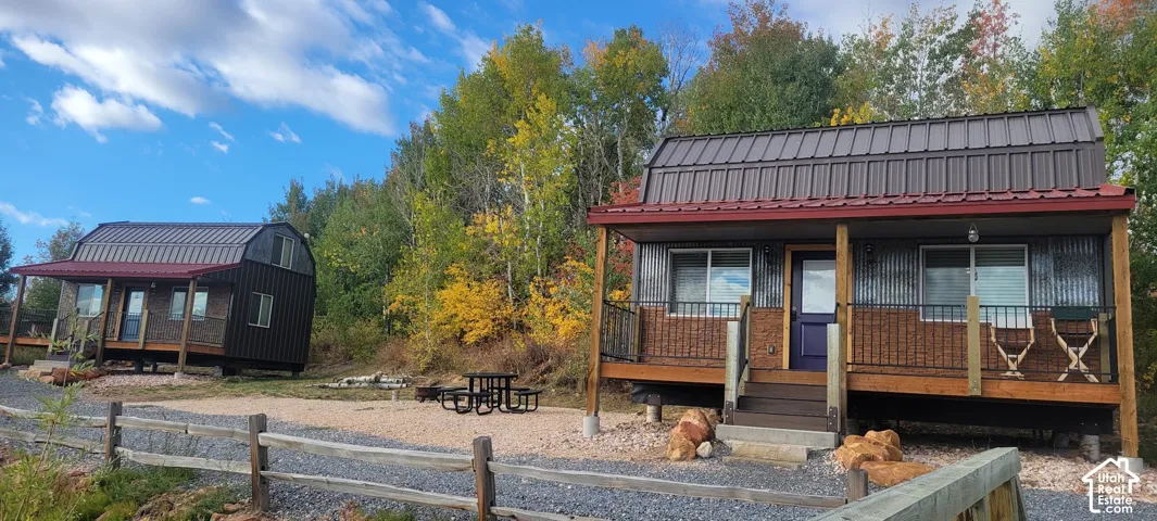Two properties featuring metal roofs, corrugated siding, and front porches