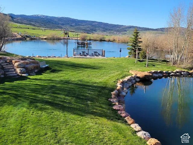 Expansive manicured lawn with a large pond and rock-lined edges