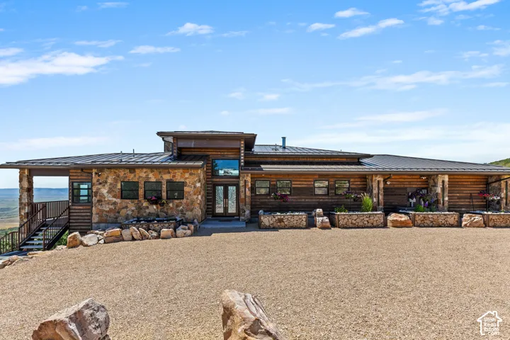 Ranch-style residence featuring natural stone and wood siding