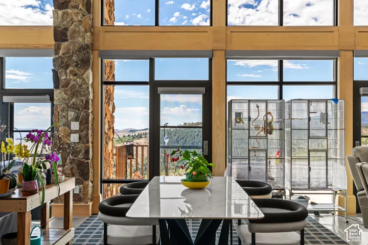 Expansive window wall with black framing, natural wood accents, and stone column detailing