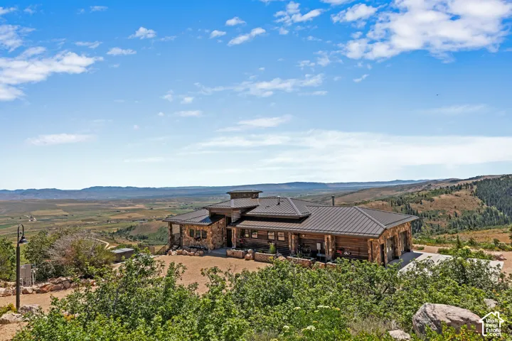 Expansive log and stone residence featuring a multi-gabled metal roof