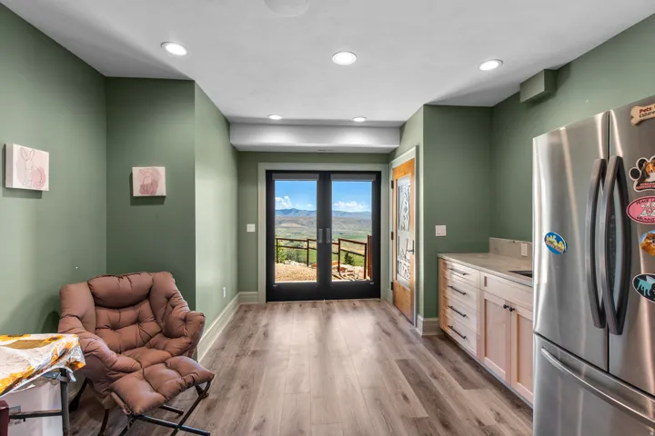 French doors opening to mountain scenery, recessed ceiling lighting, wood-finish flooring, built-in cabinetry with a stone-finish countertop, and a solid wood entry door