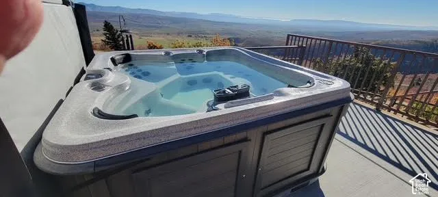 Integrated hot tub with a dark paneled exterior, set on a paved outdoor surface