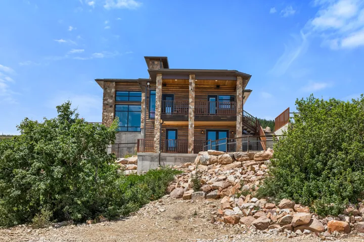 Multi-level residence featuring stacked stone and wood siding