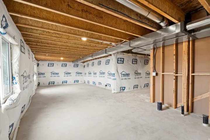 Unfinished basement offering expansive concrete flooring, exposed wood joists, and visible ductwork