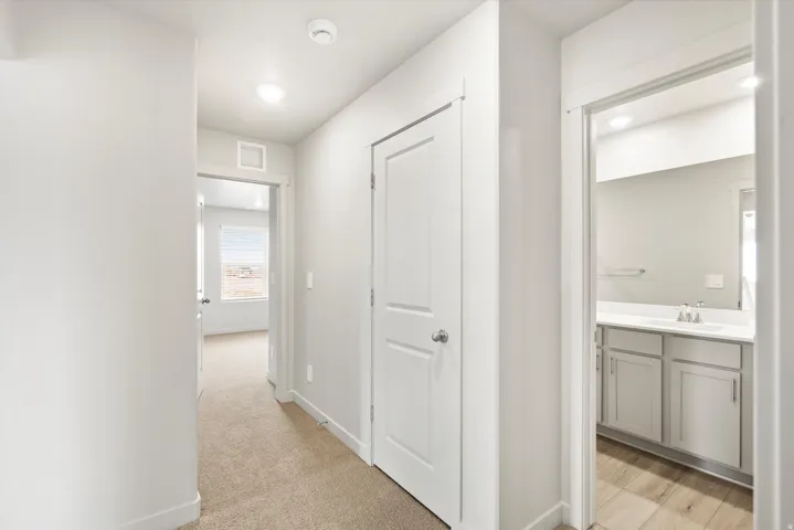 Interior hallway with carpet flooring, recessed lighting, and white walls