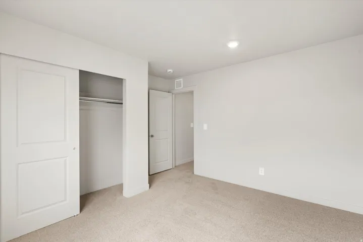 Room featuring light-colored carpeting, white baseboards, and neutral wall paint
