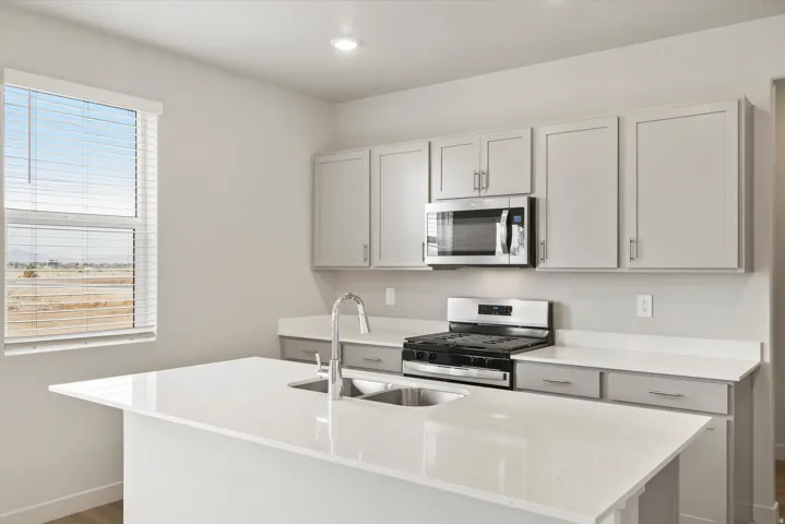 Modern kitchen featuring light gray cabinetry and white countertops