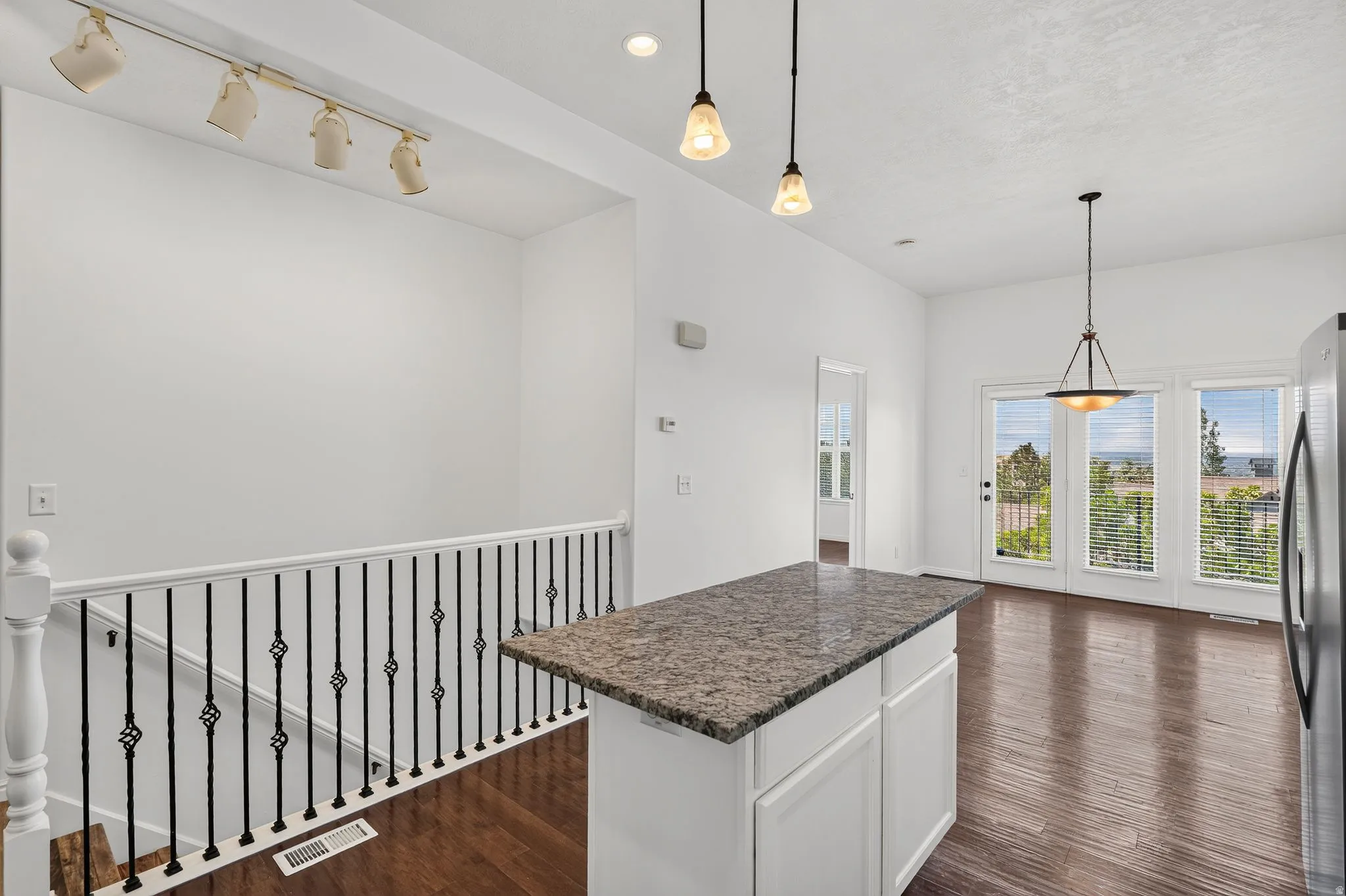 Kitchen island with a granite countertop and white cabinetry