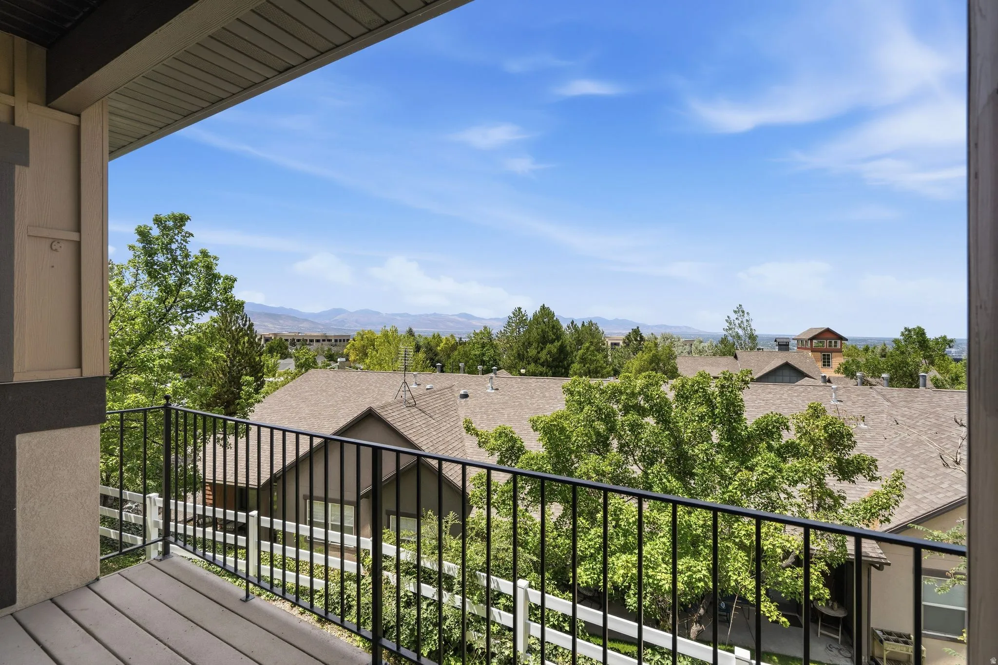 Private balcony featuring composite decking and a black metal railing