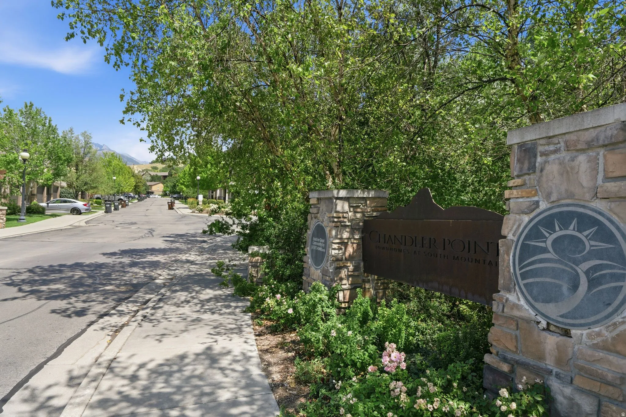 Stone and metal community entrance sign with established landscaping