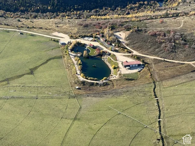 Expansive acreage featuring a private pond, multiple buildings, and agricultural fields