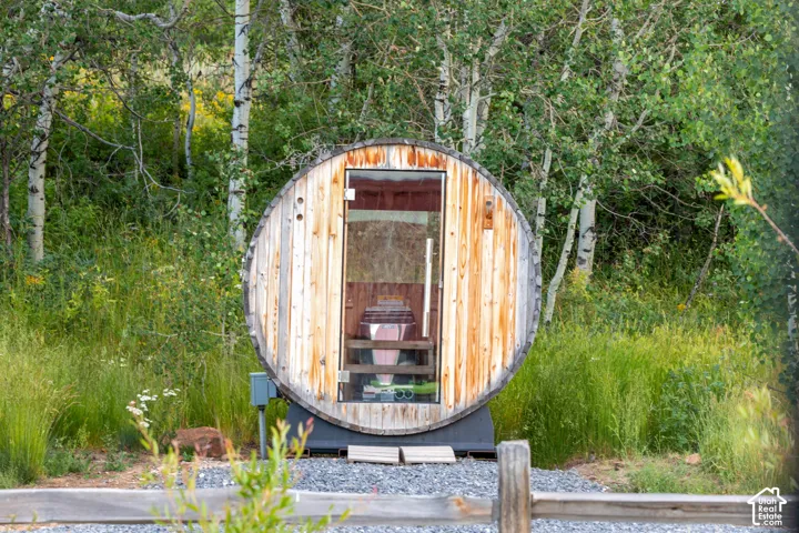 Barrel-style outdoor sauna with a clear glass door
