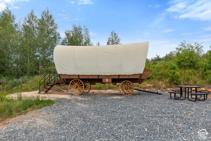 Covered wagon structure featuring a canvas top and wooden wheels