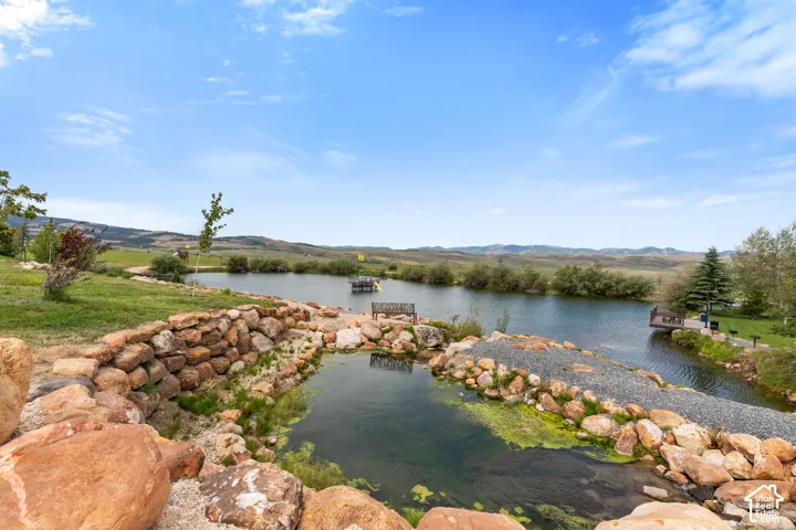Pond feature with rock landscaping and gravel pathway