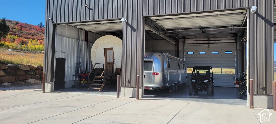 Two large overhead doors, corrugated metal siding, concrete slab, and structural beams