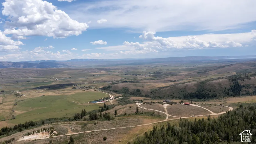 Expansive aerial perspective showcasing a vast landscape with rolling hills and distant mountains