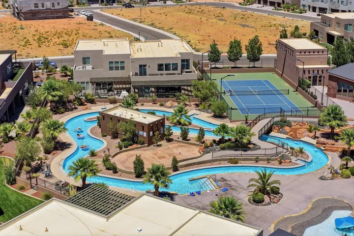 Expansive water park featuring a lazy river, surrounded by palm trees and desert landscaping