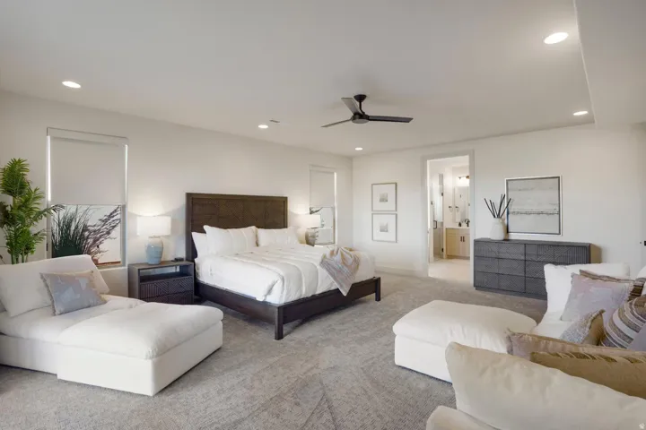 Spacious bedroom featuring plush carpeting, recessed lighting, a modern ceiling fan, and a neutral color palette