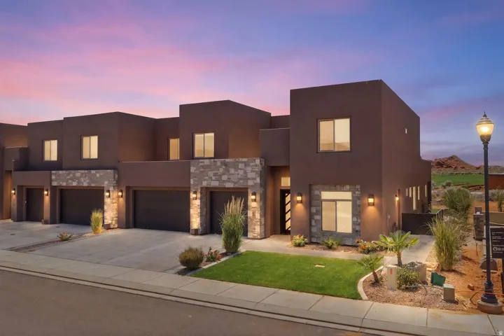 Contemporary townhome exterior featuring stucco and natural stone accents
