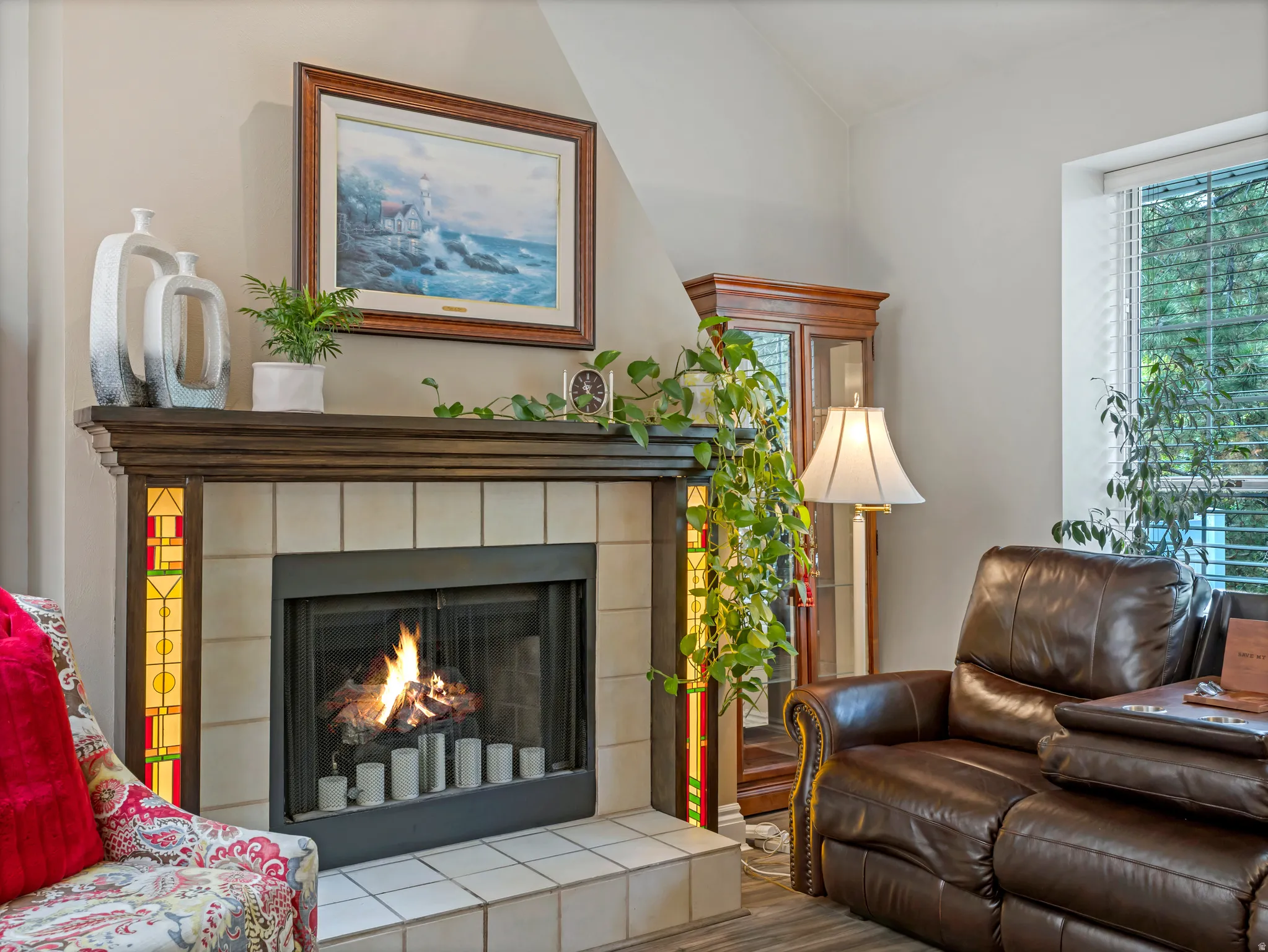 Fireplace featuring a dark wood mantel and decorative tile surround with stained glass accents