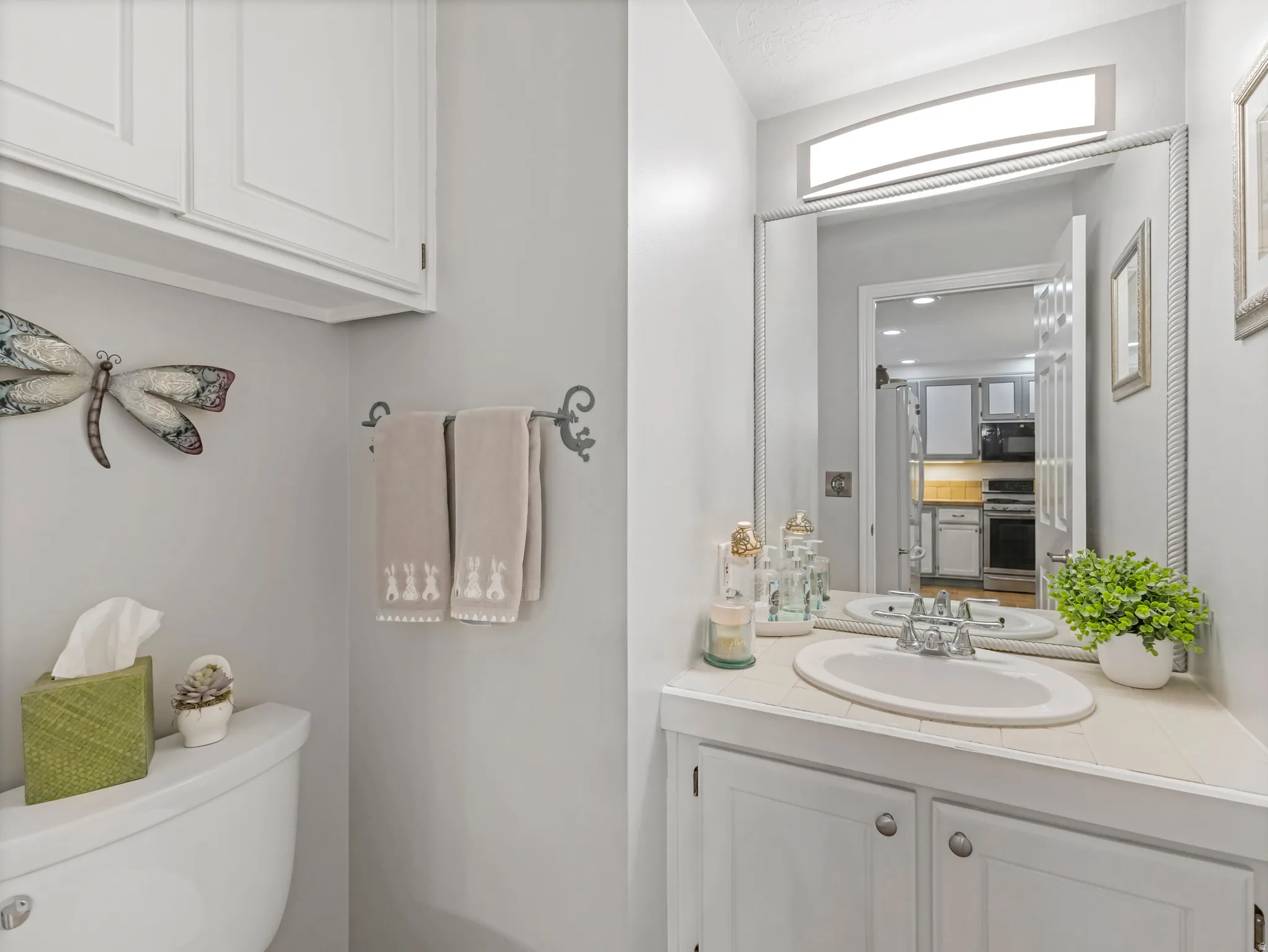 Bathroom vanity with an integrated sink, polished chrome faucet, and a large framed mirror
