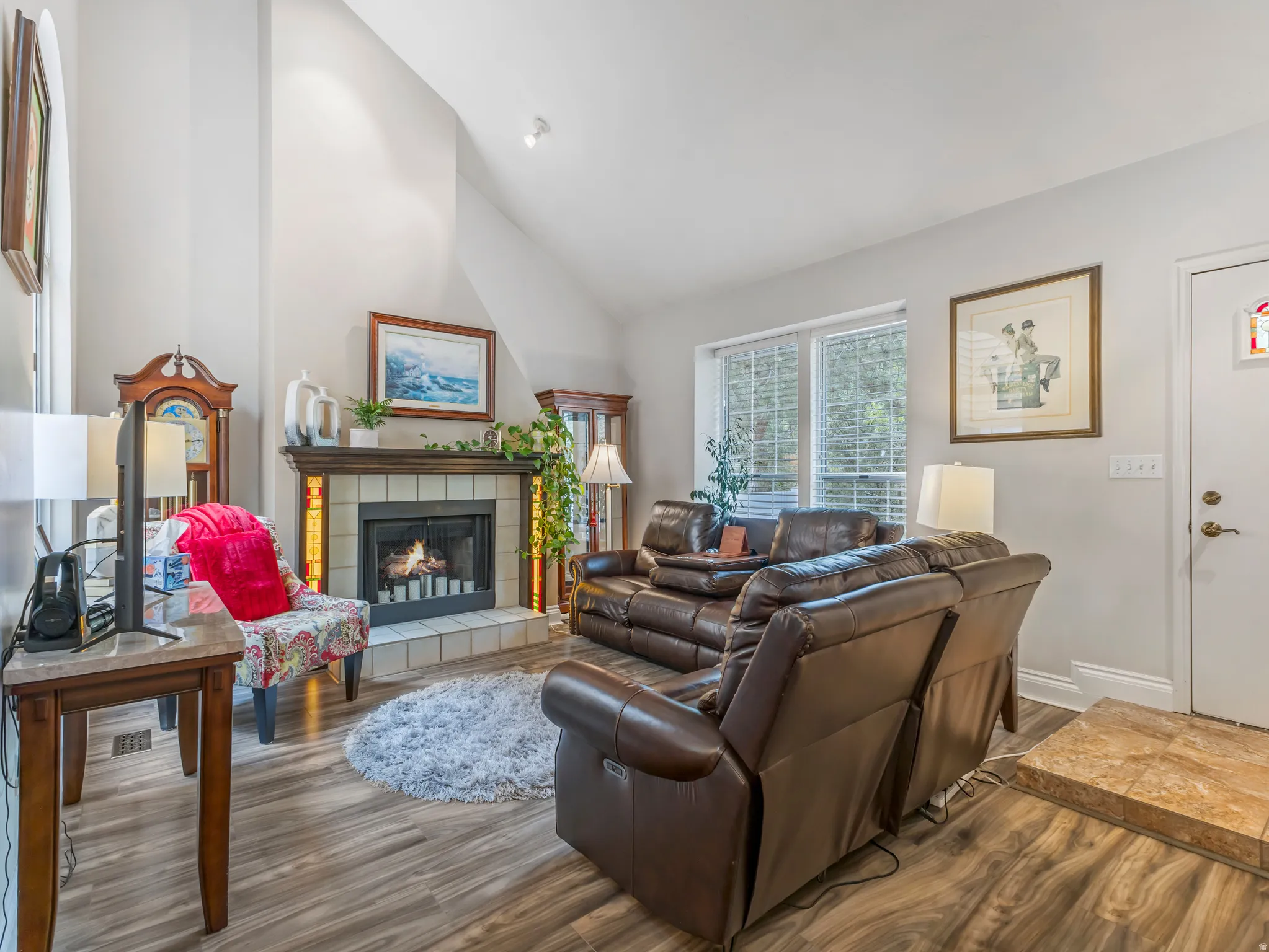 Living area featuring a vaulted ceiling and wood-finish flooring