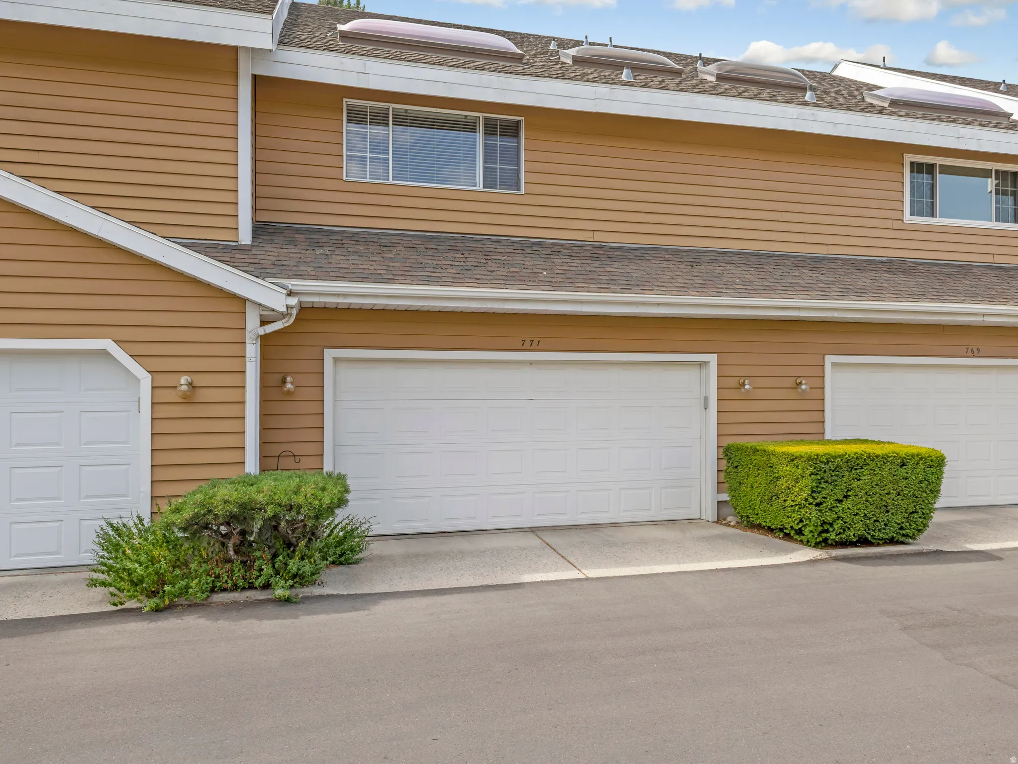 Multi-unit exterior with horizontal siding and multiple garage doors