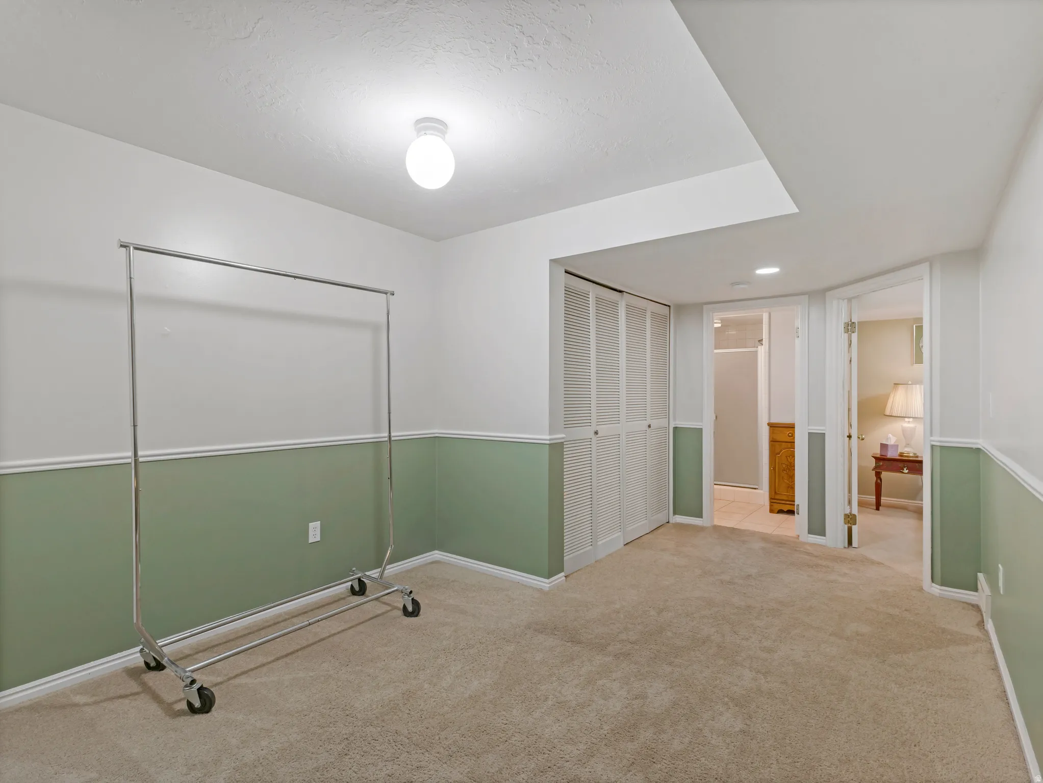 Carpeted room featuring white walls with a green chair rail