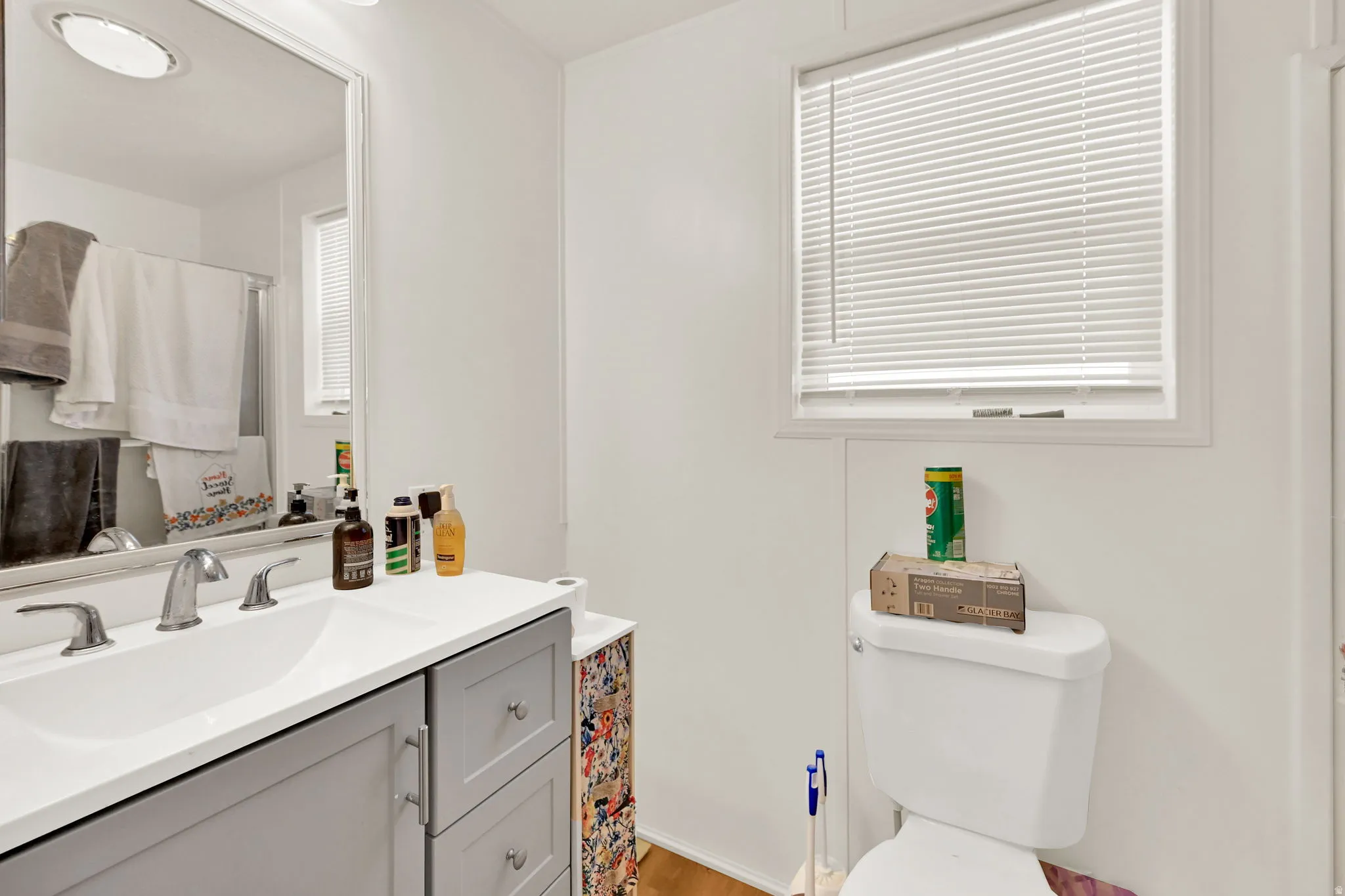 Bathroom vanity featuring a white rectangular sink, chrome fixtures, and a grey cabinet base