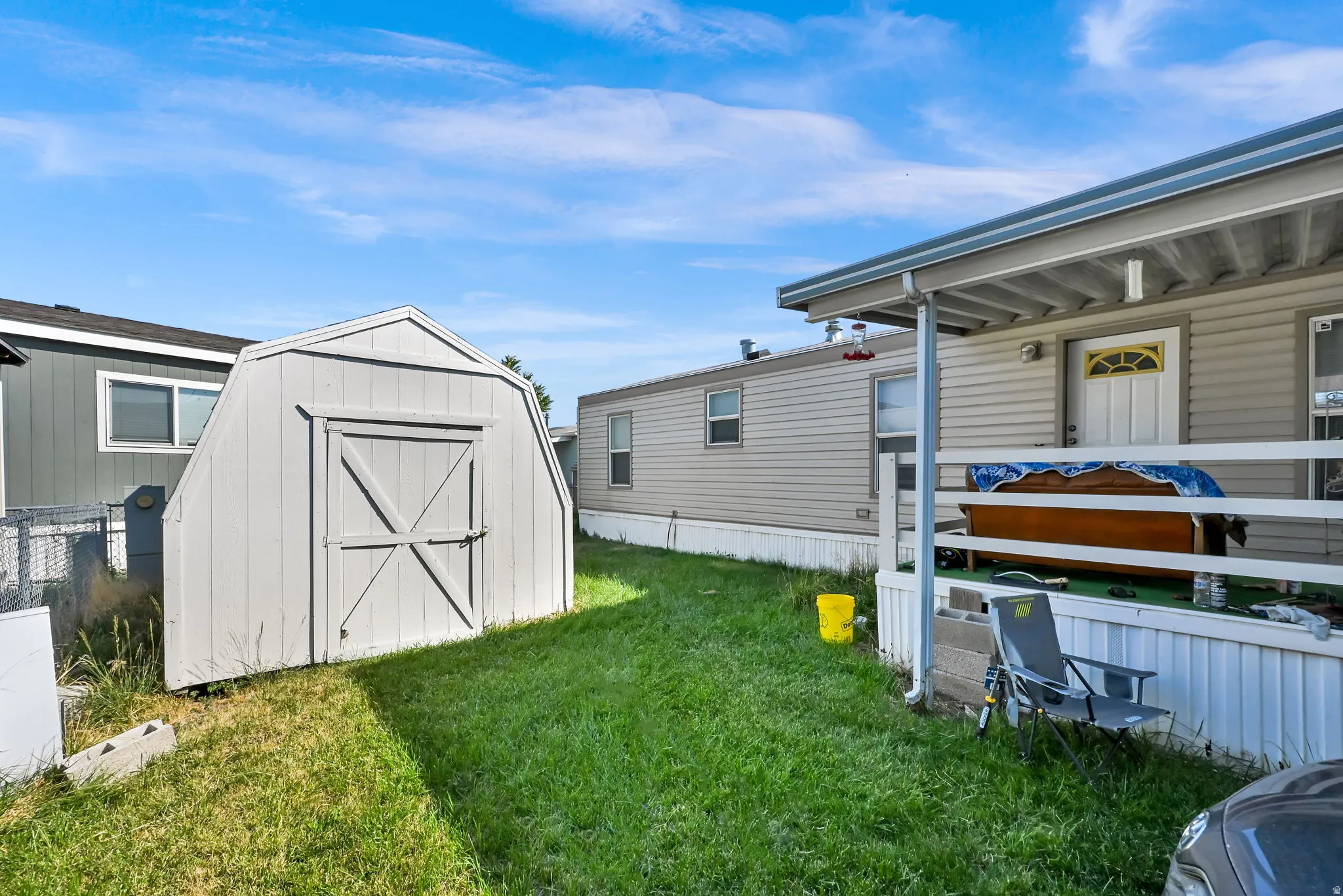 Backyard featuring a detached storage shed with double doors, an elevated deck with white railings, and siding exterior