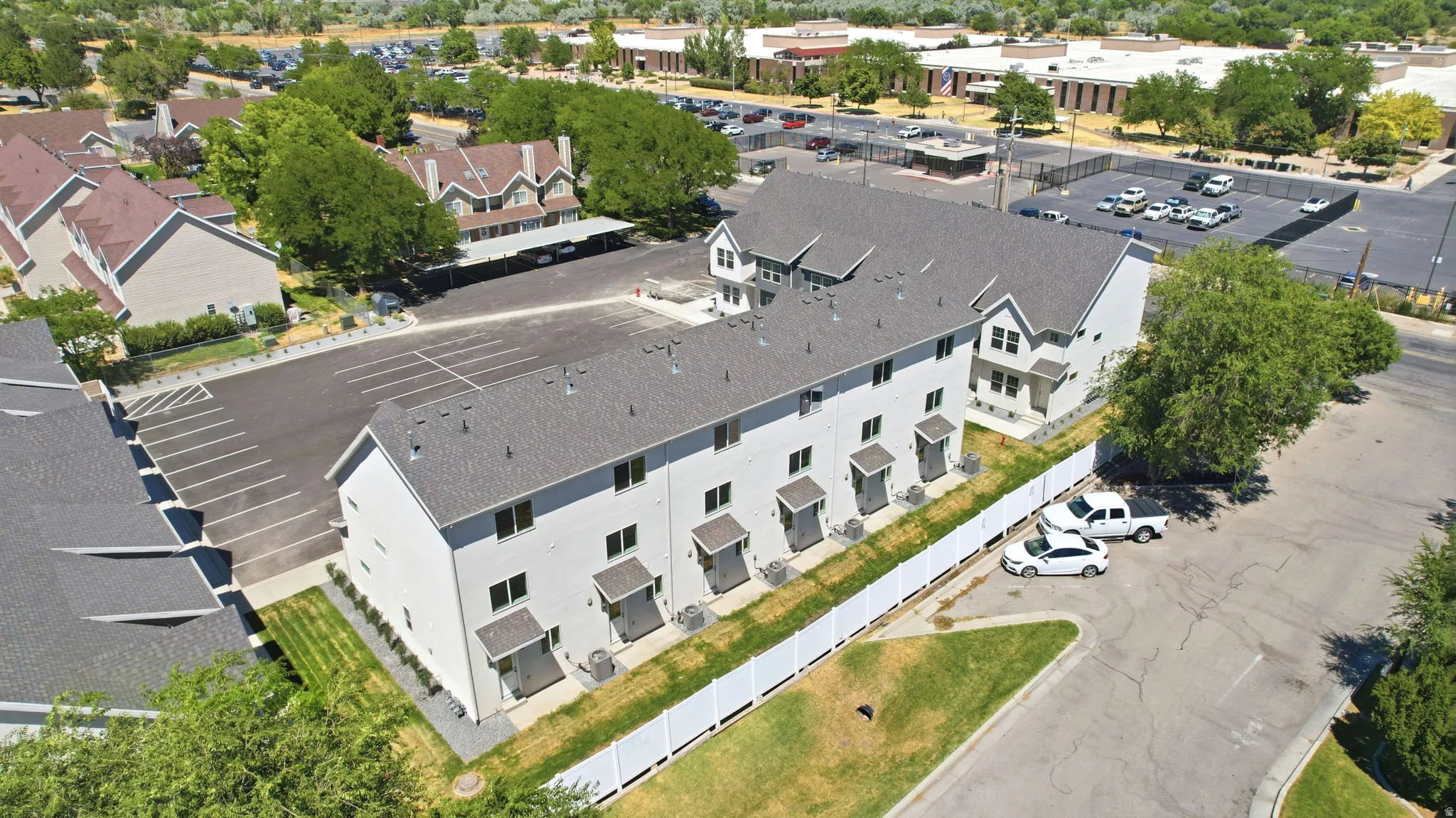 Multi-unit residential structure featuring a gray shingle roof and light-colored siding