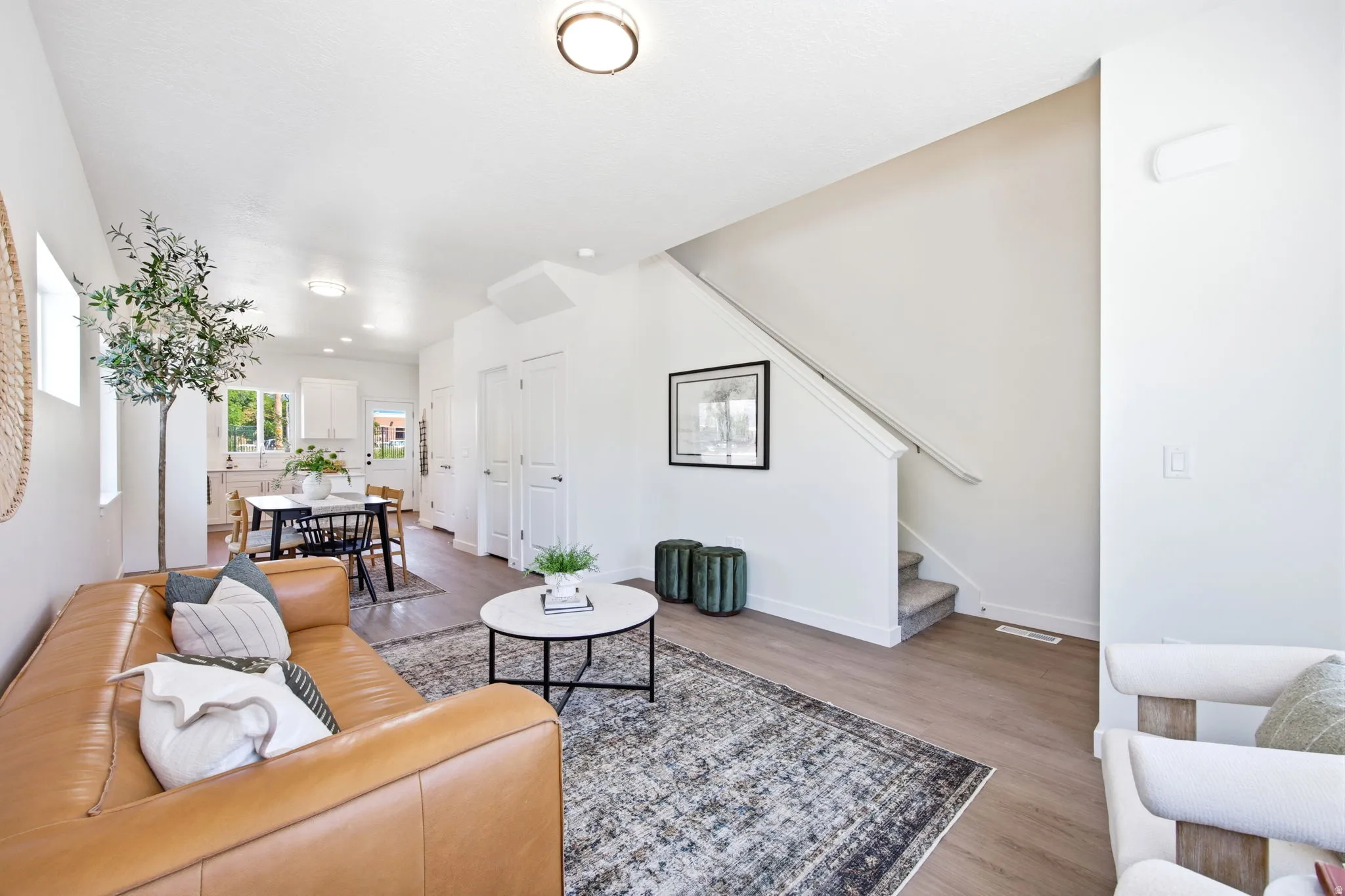 Open-concept living space featuring wood-finish flooring, recessed lighting, and a neutral color palette