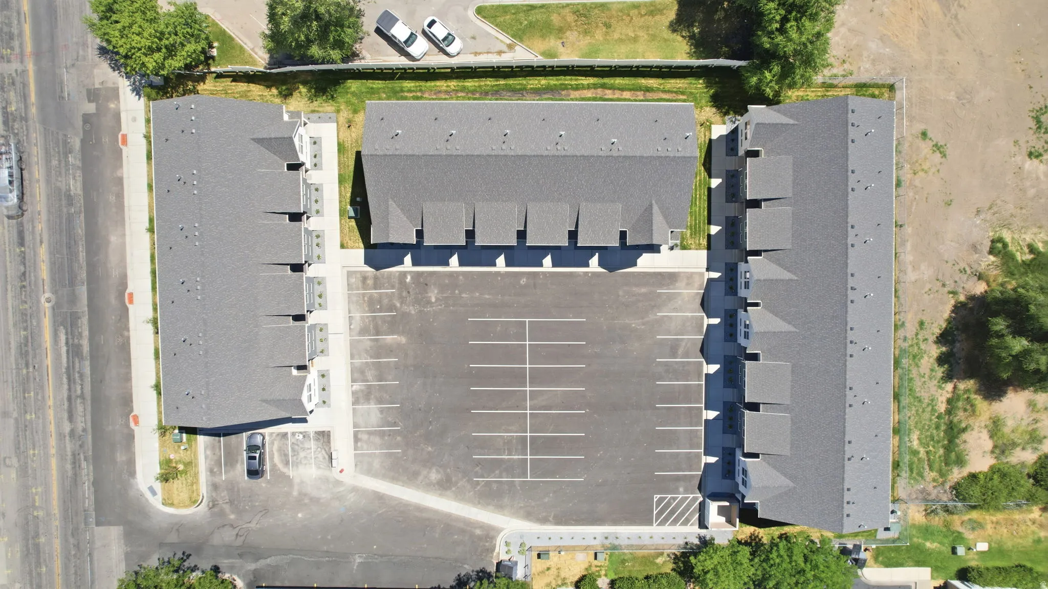 Multi-unit residential complex featuring multiple buildings with dark grey shingle roofs
