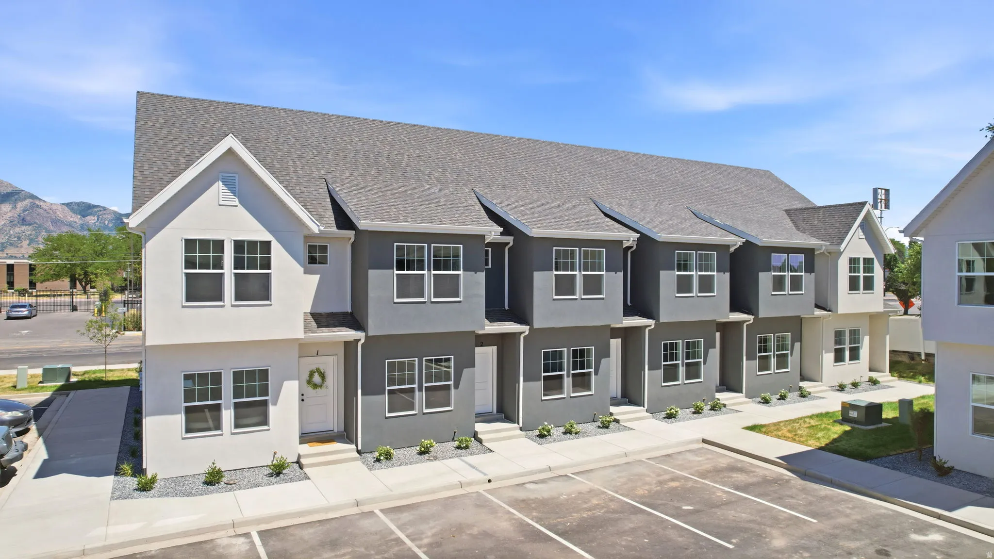 Contemporary townhome-style units with a gray and white facade